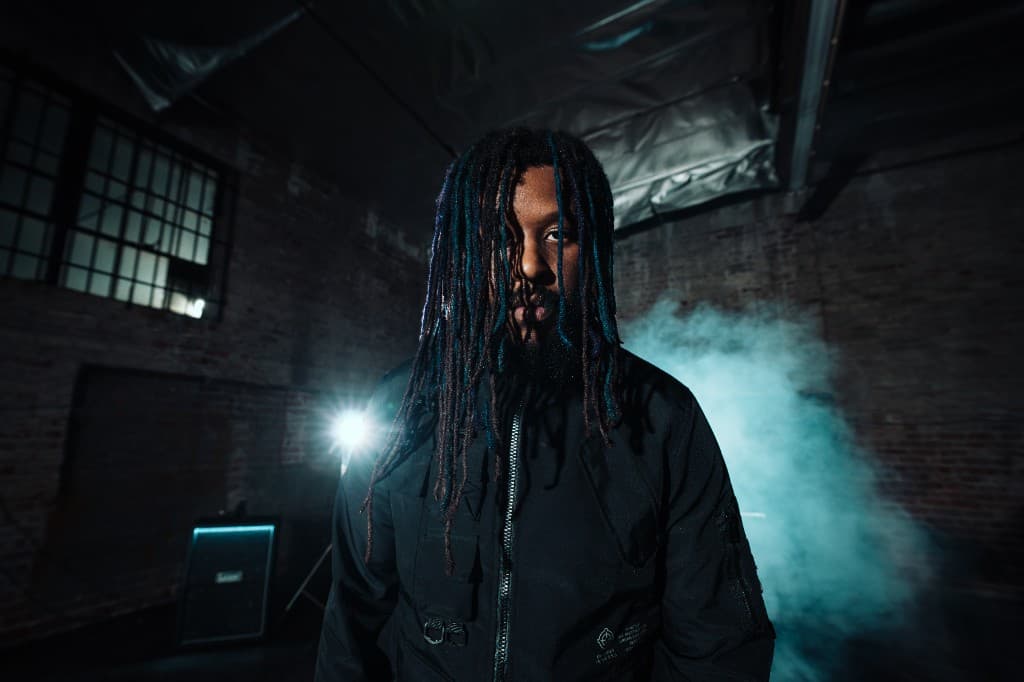 Jackson of Fall of Damascus in a black jacket, surrounded by blue smoke